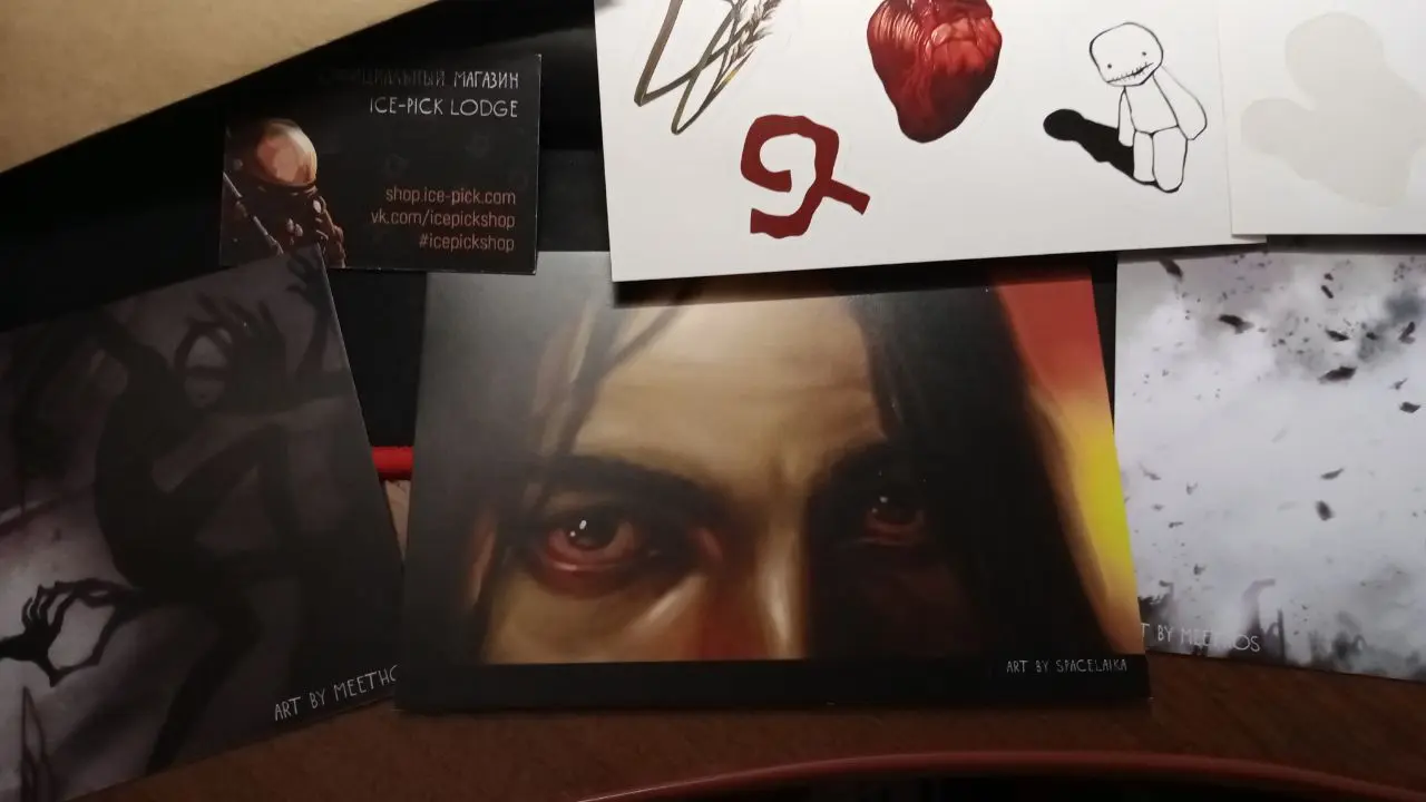 Моя коллекция. Открытки и футболки — из официального магазина Ледорубов, когда он еще существовал; где-то дома еще лежит постер с внутриигровой картины. Далее зин (или зайн?) — сборник фанатских артов, единственный, на который я не поскупилась. Есть еще маленький вязаный трагик, которого мне подарили, но на фото он не попал.