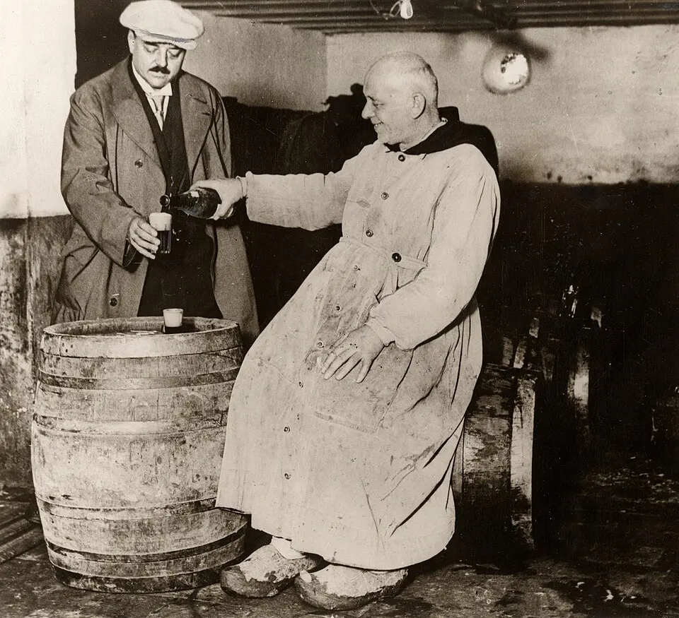 Поперинге, Бельгия (1927): в траппистской пивоварне монах в рясе и кломпах предлагает гостю пиво. Автор неизвестен