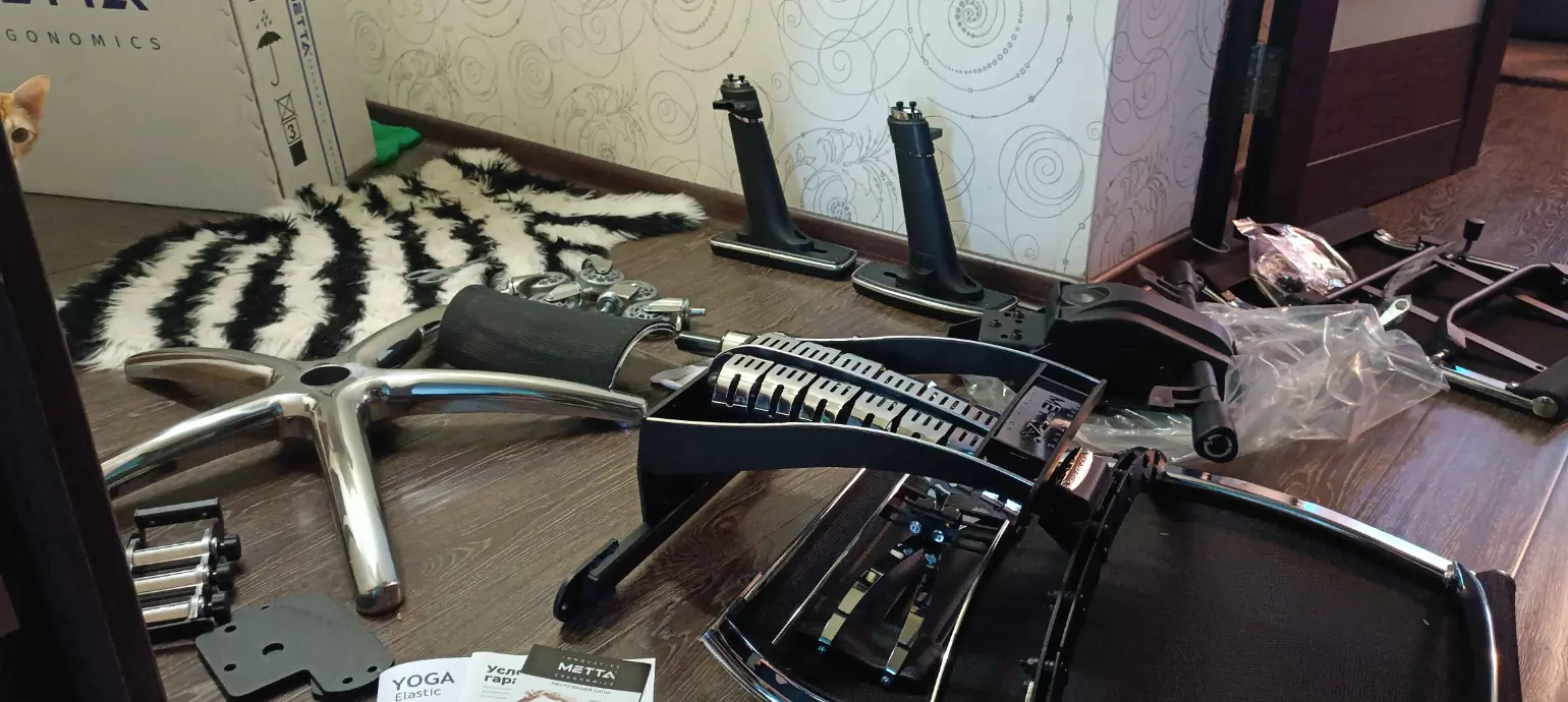 Части кресла согреваются до комнатной температуры перед установкой (газлифт не рекомендуется устанавливать холодным), а Котэ пришёл жевать упаковки.